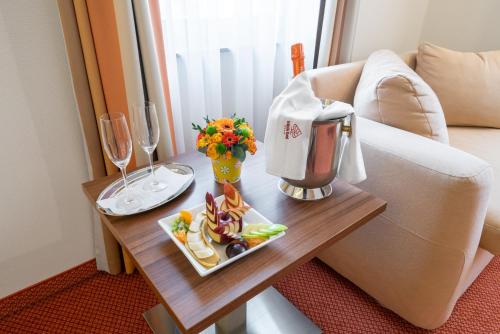 a table topped with a coffee cup and a vase of flowers at Bükkös Hotel & Spa in Szentendre