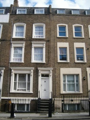 a large brick building with white windows and a white door at Daisy Hotel in London
