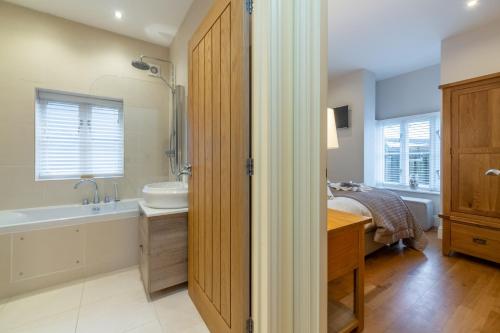 a bathroom with a tub and a sink and a bath tub at 5 Fernhill in Carbis Bay