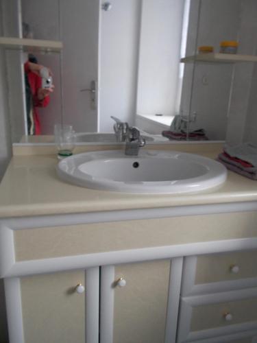 a white sink in a bathroom with a mirror at Ti va zud in Plouguerneau