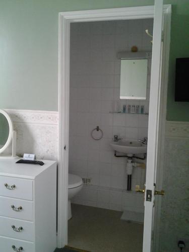 a bathroom with a toilet, sink, and mirror at The Mount View Hotel, Bed & Breakfast in Penzance