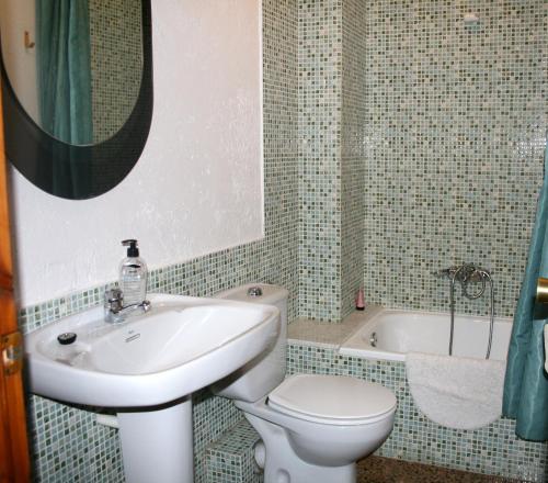 a bathroom with a sink and a toilet and a tub at Cal Xesc in Castellar de NʼHug