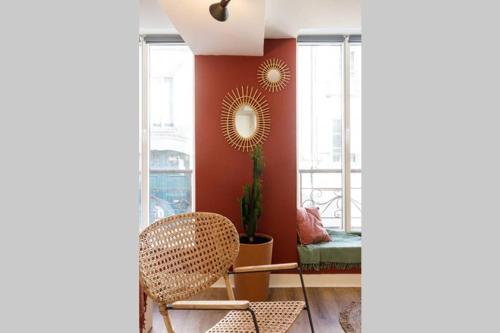 - un salon avec une chaise et un mur rouge dans l'établissement Appartement chaleureux en centre-ville de Caen, à Caen
