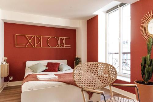 a bedroom with a bed with a red wall at Appartement chaleureux en centre-ville de Caen in Caen