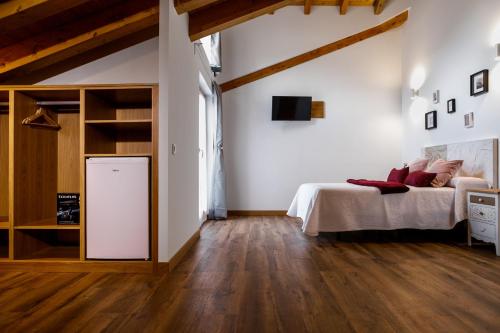 a bedroom with a bed and a wooden floor at Posada rural Fuente Juliana in Barrio de Arriba
