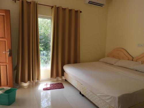 1 dormitorio con cama y ventana grande en Karaa Village en Thoddoo