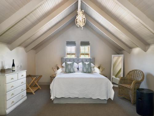 ein Schlafzimmer mit einem weißen Bett und einer weißen Decke in der Unterkunft Mont d'Or Franschhoek in Franschhoek