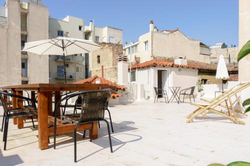 a table and chairs with an umbrella on a patio at Acropolis Heights at the foot of the Parthenon in Athens
