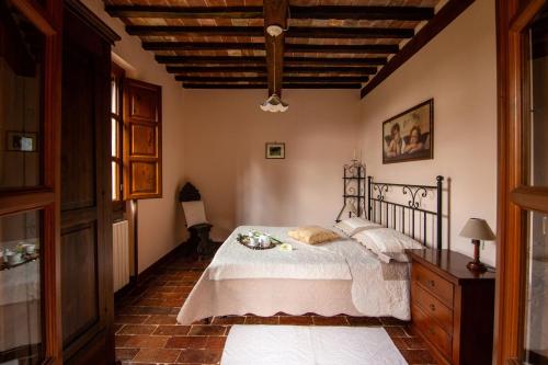 Un dormitorio con una cama y un techo de madera. en Collina dei Fiori, en Castiglion Fiorentino