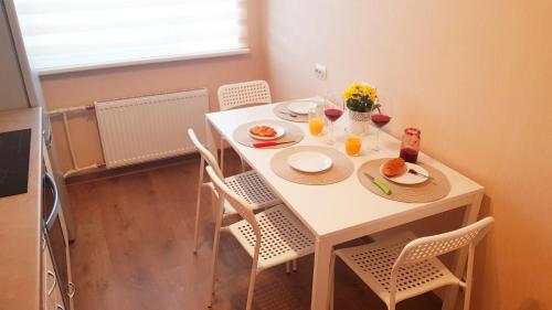 einen kleinen weißen Tisch mit Teller mit Lebensmitteln drauf in der Unterkunft Birch view apartment in Jelgava