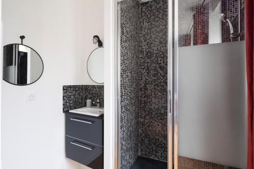 a bathroom with a shower with a sink and a mirror at Le Code 0 by Cocoonr in Saint Malo