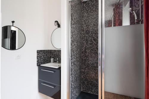 une salle de bain avec une douche avec un lavabo et un miroir dans l'établissement Le Code 0 by Cocoonr, à Saint-Malo