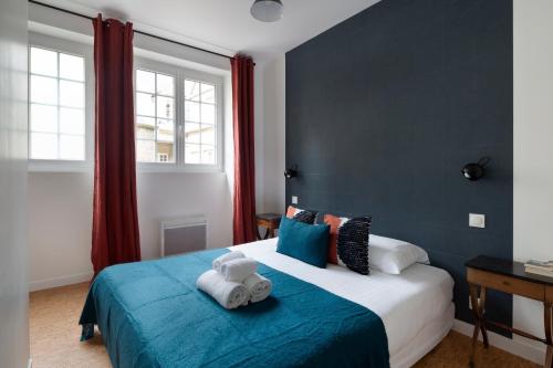 une chambre avec un lit avec deux animaux en peluche dessus dans l'établissement Le Code 0 by Cocoonr, à Saint-Malo