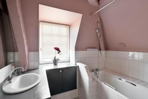 La salle de bains est pourvue d'un lavabo, d'une baignoire et d'une fenêtre. dans l'établissement Le Marco Polo by Cocoonr, à Saint-Malo