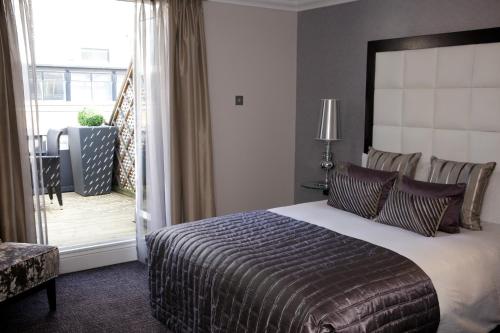 a bedroom with a large bed and a large window at The Chamberlain in London