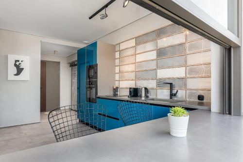a kitchen with blue cabinets and blue chairs at Onira Suite Dreams in Hersonissos