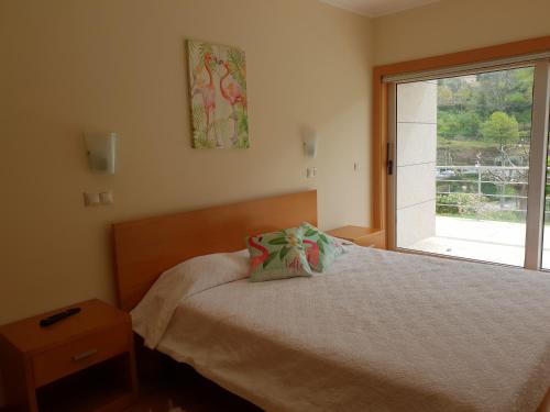 a small bedroom with a bed and a window at Casinhas do Gerês in Geres