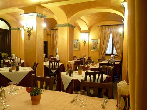 restauracja ze stołami i krzesłami w pokoju w obiekcie Albergo Ristorante Cavallo Bianco w mieście Dronero