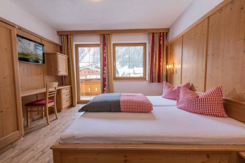 a bedroom with a large bed with red and grey pillows at Alpenchalet Vital in Neustift im Stubaital