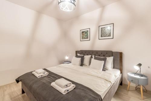a bedroom with a large bed with two towels on it at Modern and Stylish Apartment w Terrace in Cluj-Napoca