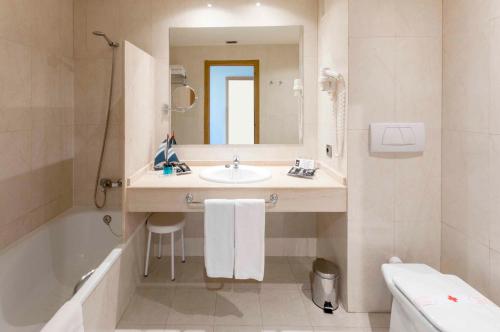 
a bathroom with a sink, toilet and bathtub at VS Gandía Palace Hotel **** in Gandía

