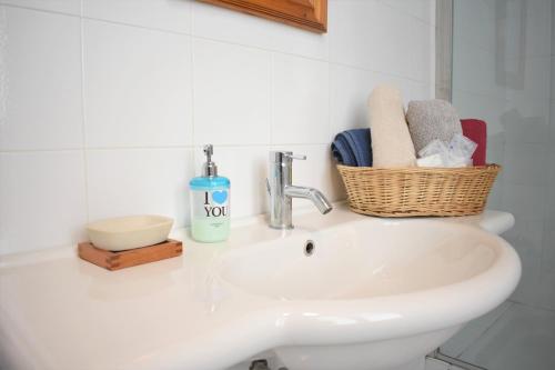 a white bathroom sink with a basket on top of it at Villa Scalabrini in Como