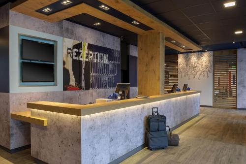 a lobby with a reception counter with a suitcase at Ibis budget Wien Sankt Marx in Vienna
