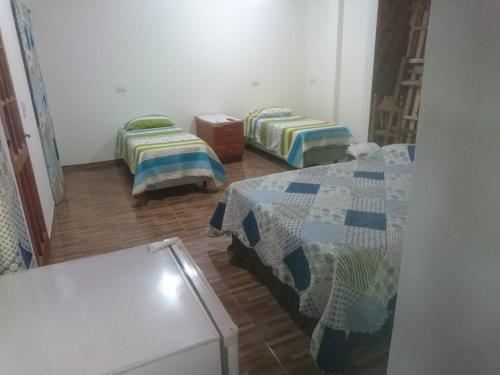 a room with two beds in a room at Alojamiento de la ABU in Puerto Iguazú