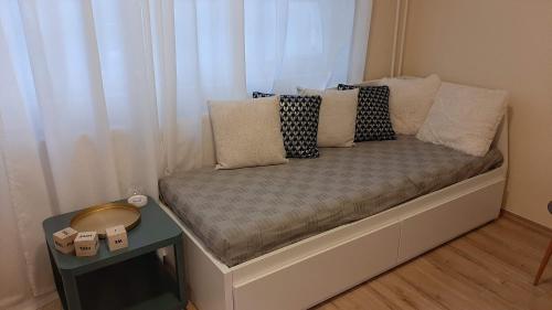 un pequeño sofá con almohadas en una habitación en MHC Stúdió, en Kaposvár