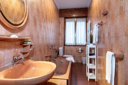 Un baño con lavabo, inodoro y espejo. en Il Terrazzino sul Lago, en Bellagio