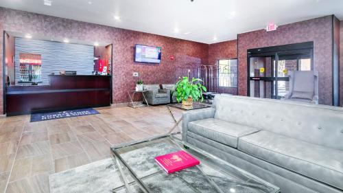 a lobby with a couch and a bar at Cobblestone Hotel & Suites - Janesville in Janesville