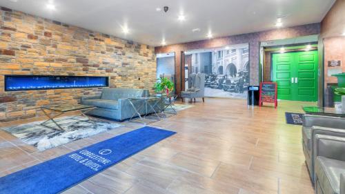 a lobby with a couch and a brick wall at Cobblestone Hotel & Suites - Janesville in Janesville