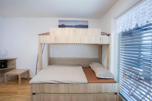 een slaapkamer met een stapelbed en een raam bij Studio Novak Bled in Bled