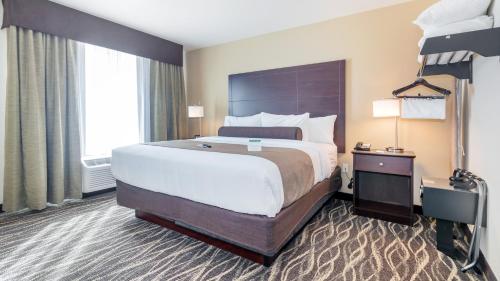 a bedroom with a large bed and a large window at Cobblestone Hotel & Suites - Janesville in Janesville