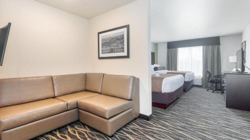a hotel room with a couch and a bed at Cobblestone Hotel & Suites - Janesville in Janesville
