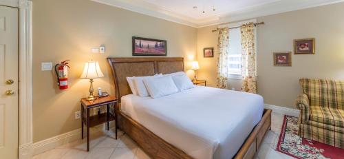 a bedroom with a large bed and a chair at Chipman Hill Suites - Union Street in Saint John