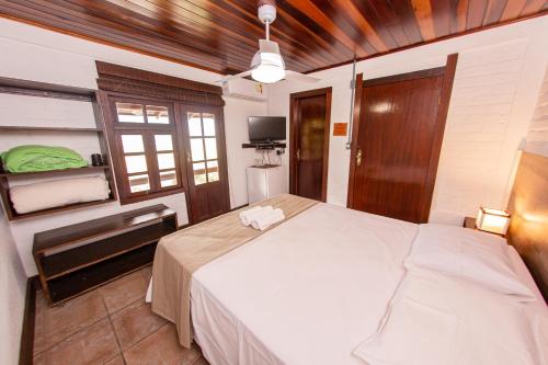a bedroom with a large white bed in a room at Pousada Colina Verde in Garopaba