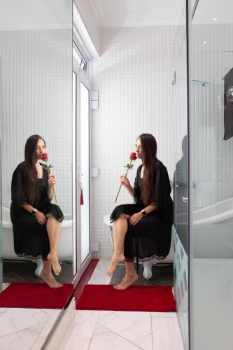 a woman sitting in a chair in front of a mirror at AI Adrian D'Cap Boutique Manor in Stellenbosch