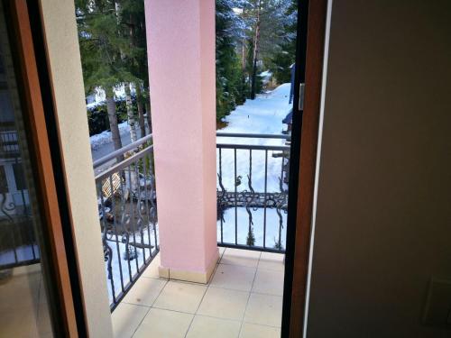 an open door to a balcony with snow on the ground at Vila Meridijan in Zlatibor