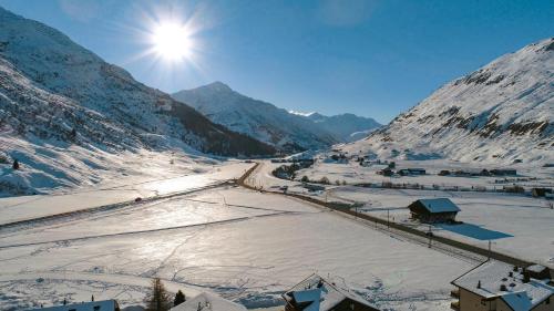 a snow covered mountain with the sun in the sky at Haus Sonnboden in Andermatt