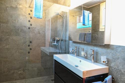 a bathroom with a sink and a shower at Haus Sonnboden in Andermatt