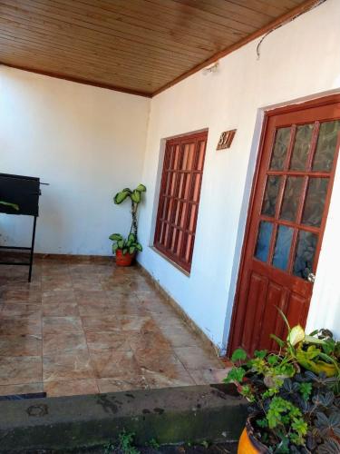 a room with a red door and a piano at Alojamiento de la ABU in Puerto Iguazú