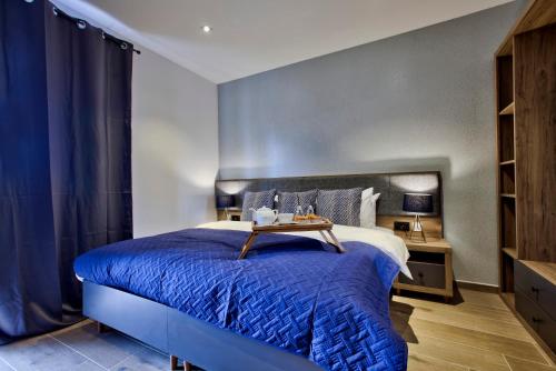 a bedroom with a blue bed with a blue blanket at Tritoni Valletta Boutique Hotel in Il-Furjana