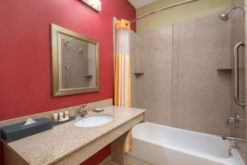 a bathroom with a sink and a shower and a tub at La Quinta by Wyndham Atlanta Union City in Union City