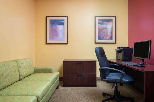 a room with a couch and a desk with a computer at La Quinta by Wyndham Atlanta Union City in Union City