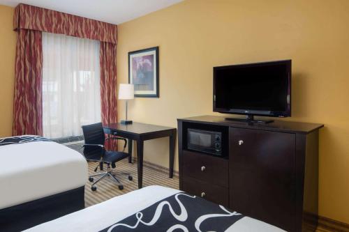 a hotel room with a bed and a flat screen tv at La Quinta by Wyndham Atlanta Union City in Union City