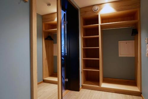 ein Zimmer mit einem Kleiderschrank mit Holzregalen in der Unterkunft Skeikampen Servicesenter in Svingvoll