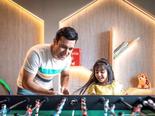 a man and a little girl looking at toy dolls at ibis Jaipur City Centre - An Accor Brand in Jaipur