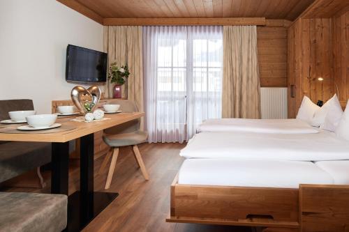 a hotel room with two beds and a desk at Frühstückspension Klinglhub in Flachau