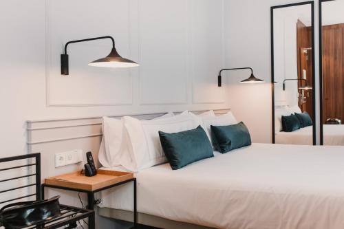 sypialnia z dużym białym łóżkiem z niebieskimi poduszkami w obiekcie Helen Berger Boutique Hotel w Walencji